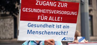 Bild eines Plakats mit dem Text: Zugang zur Gesundheitsversorgung für alle! Gesundheit ist ein Menschenrecht!