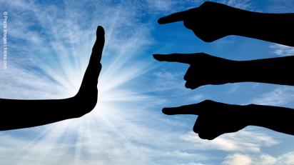 Gegen Diskriminierung Drei Finger zeigen auf eine abwehrende Hand