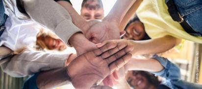 Hände Menschen stehen im Kreis und legen ihre Hände übereinander