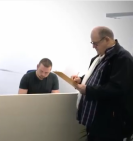 Ein Patient steht am Empfangstresen einer Arztpraxis