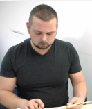 Ein Arzthelfer sitzt hinter dem Empfangstresen