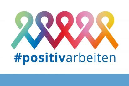 bunte rote Schleifen, darunter der Schriftzug "positiv arbeiten"