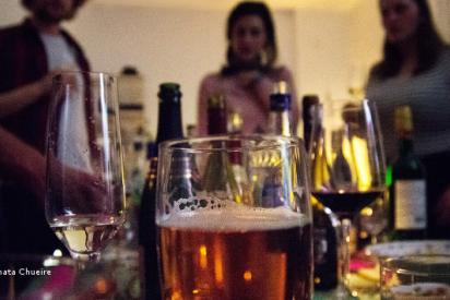Blick auf eine Partyszene, im Vodergrund stehen mehrere alkoholische Getränke, im Hintergrund die Silhouetten von einigen Menschen