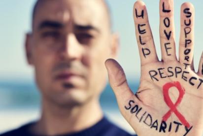 Mann streckt Handfläche zur Kamera. Darauf steht: Respect und Solidarity. In der Mitte die rote Aids-Schleife.