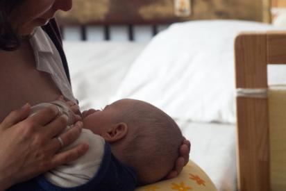 Eine stillende Mutter mit einem Baby an der Brust zur Illustration von Kinderwunsch bei HIV