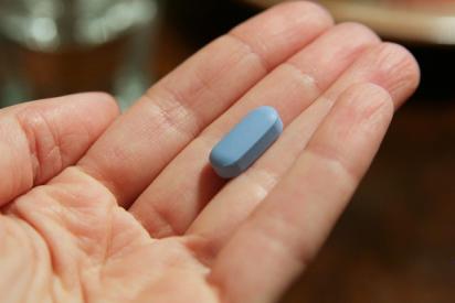 auf einer Handinnenfläche liegt eine blaue Pille